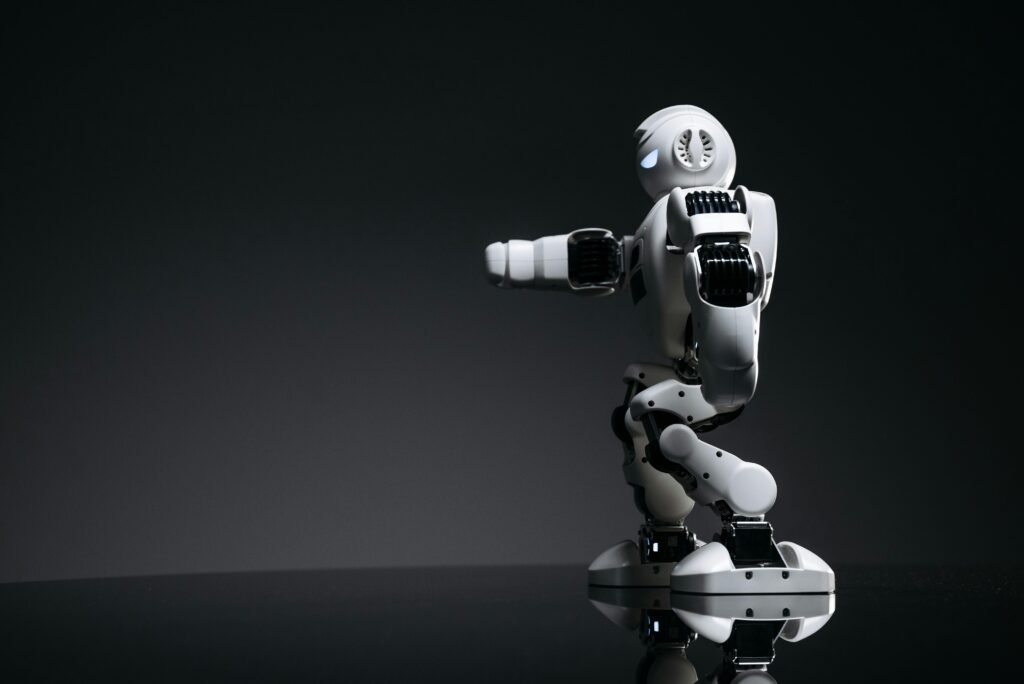 A white robot showcasing modern design on a sleek dark surface.